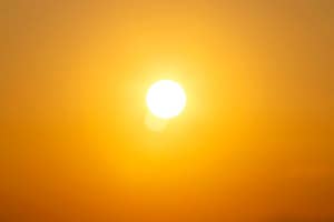 A bright sun in a clear sky creating a warm, glowing ambiance
